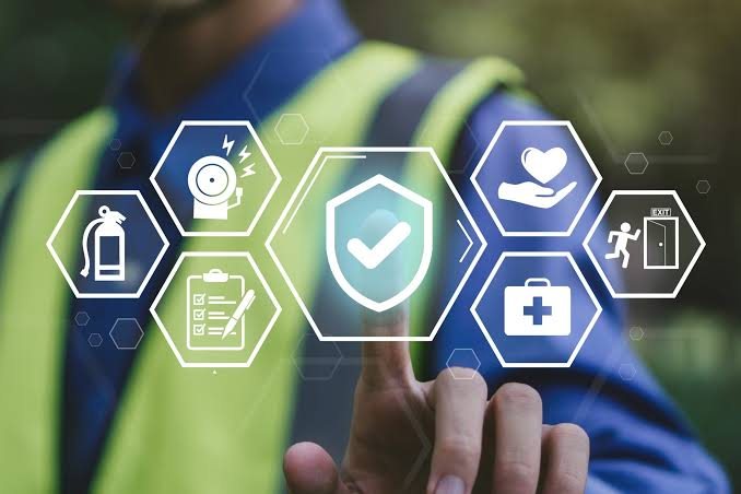 Profissional tocando em ícones de segurança do trabalho: proteção, checklist, primeiros socorros e prevenção de incêndio